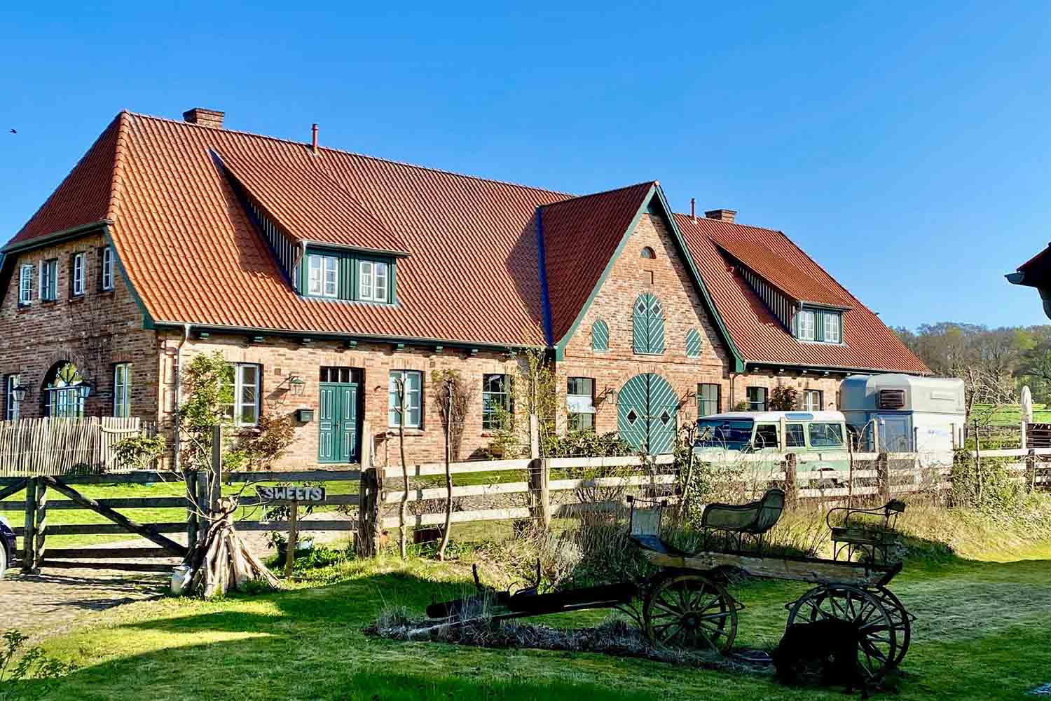 Backsteinhaus mit grünem Hoftor und Vorgarten in Pronstorf
