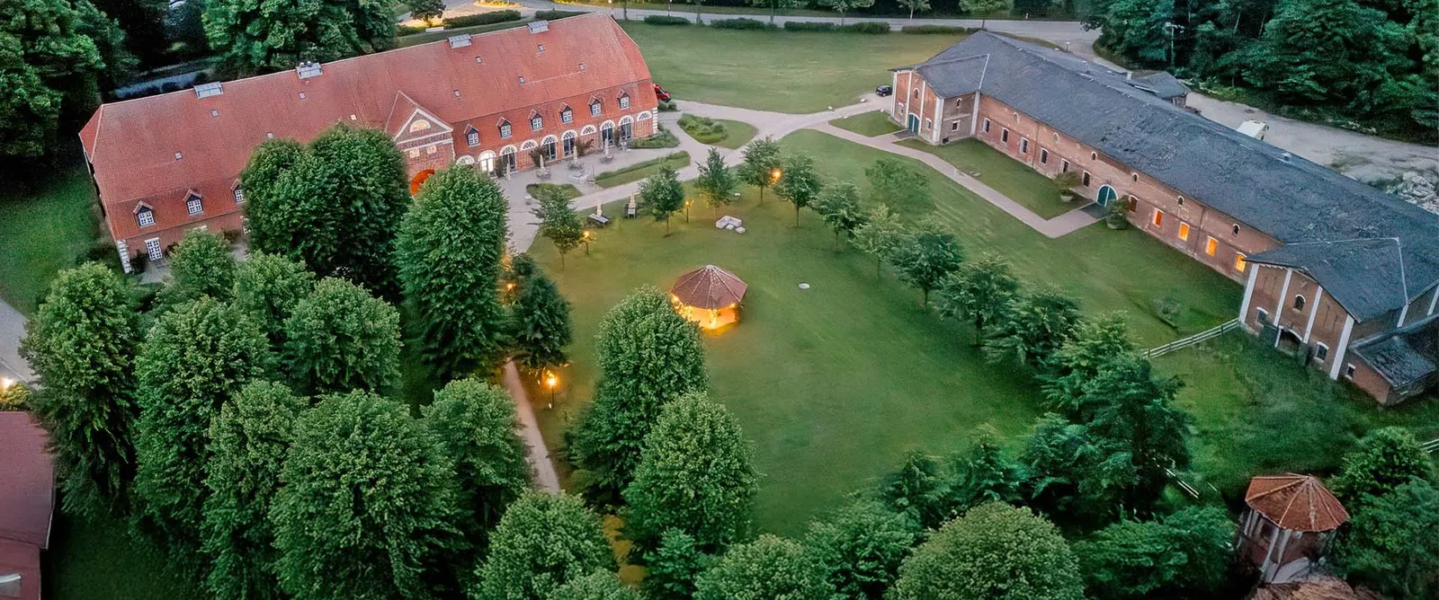 Luftaufnahme von Gut Pronstorf mit Torhaus, Wirtschaftsgebäuden und dem grünen Gutshof