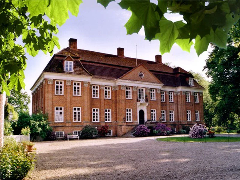 Das Herrenhaus auf Gut Pronstorf, eingerahmt von sommerlichem Grün